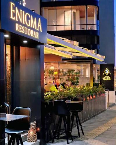 The Enigma Restobar entrance at dusk, with outdoor seating